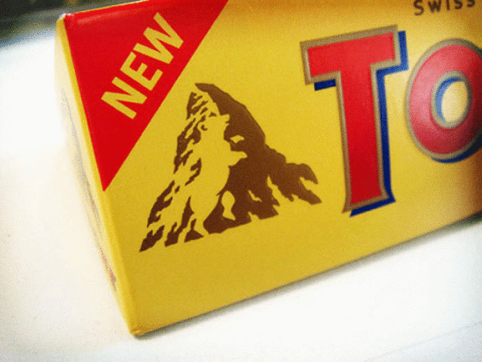 Медведь на фоне горы на логотипе шоколадного батончика.