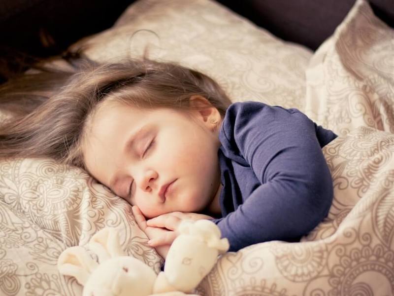 Ребенок спит на кровати родителей
